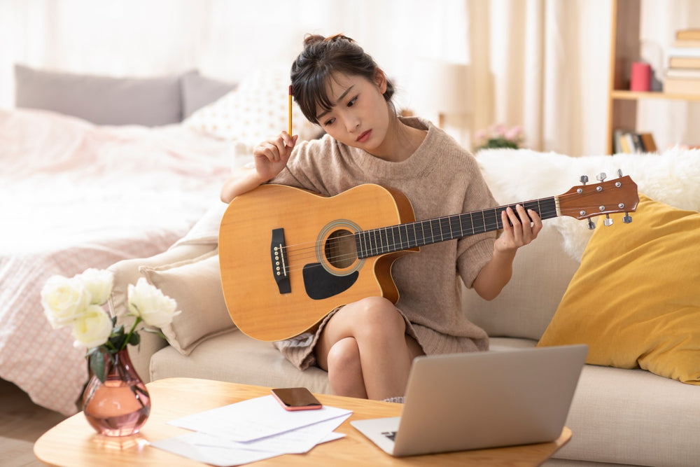 Woman looking confused while learning guitar
