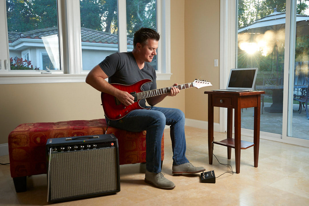 Man playing electric guitar using  Vidami Youtube looper while watching lesson on laptop. The Fastest way to Learn on Youtube. Control videos handsfree by looping and slowing down the video. Keep you hands on your instrument. 